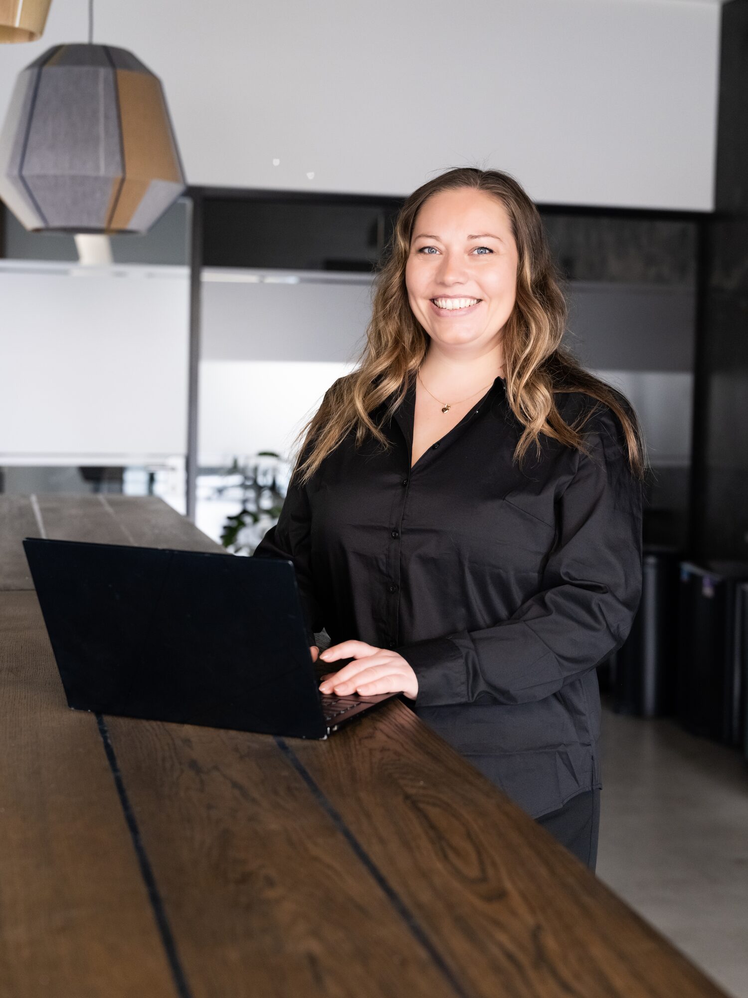 Kamilla Vinding med laptop i mødelokale